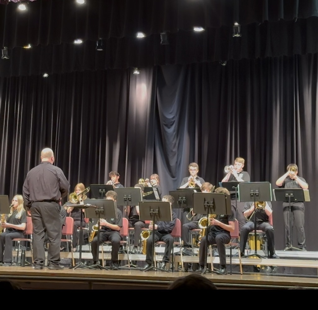 band director on stage with the jazz band members