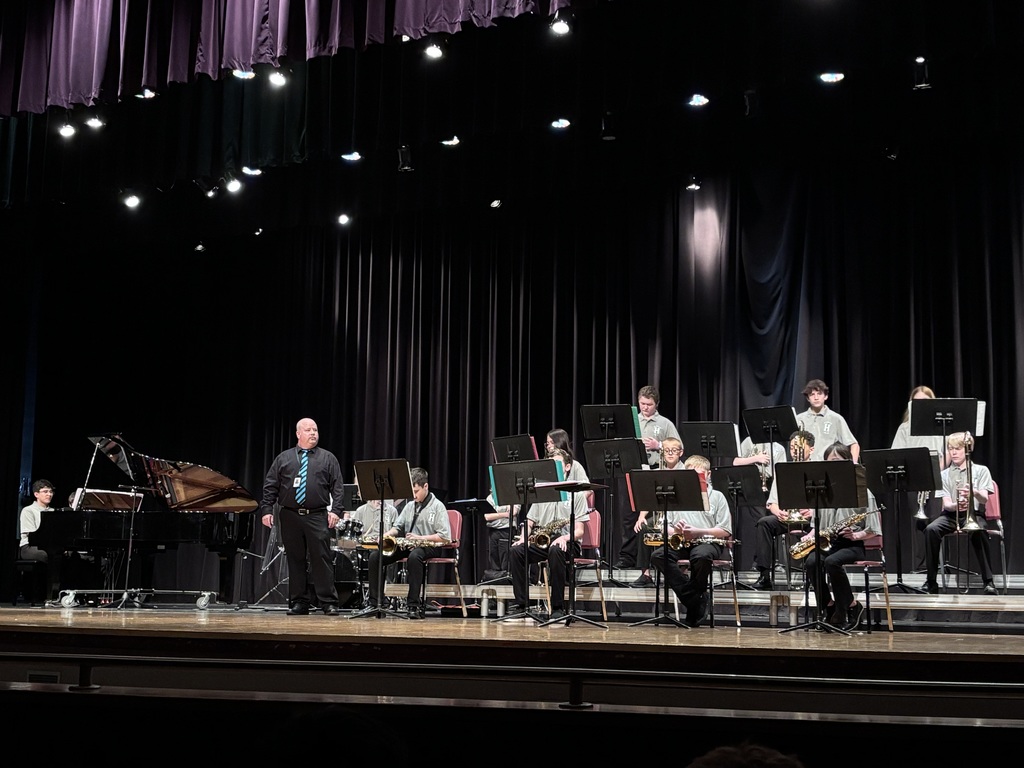 band director on stage with the jazz band members