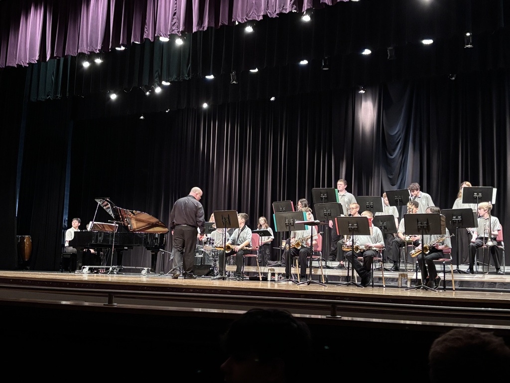 band director on stage with the jazz band members