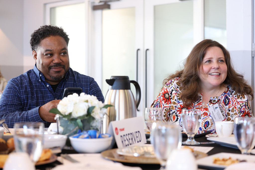 Trane employees at the breakfast table smiling.
