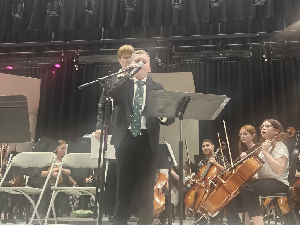 Student speaking at strings concert.