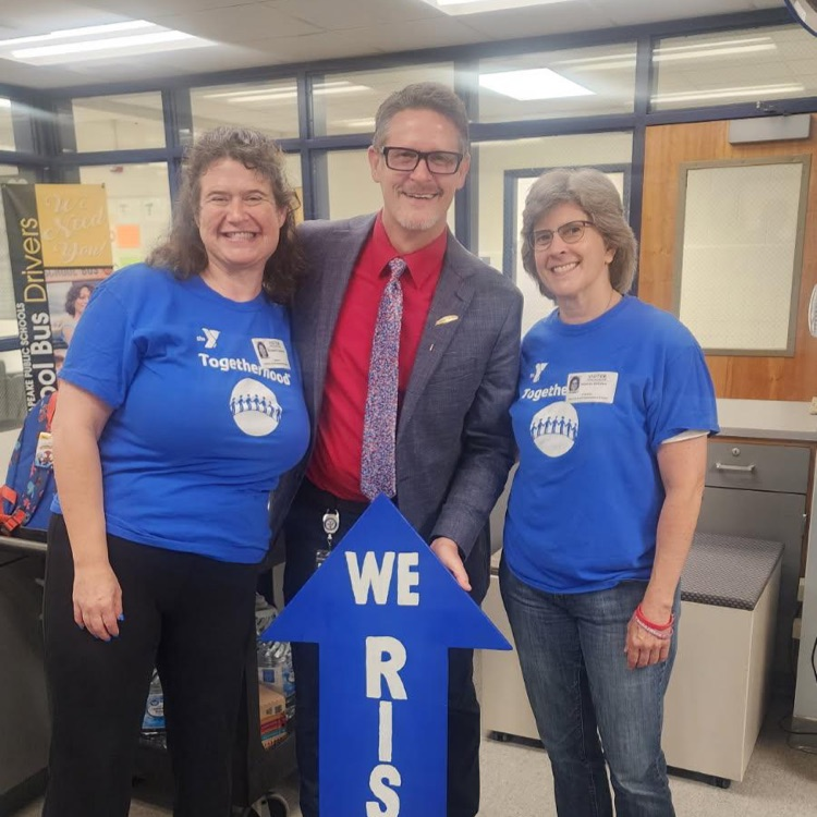 ymca employees with Mr. Triolet and the We RISE sign.