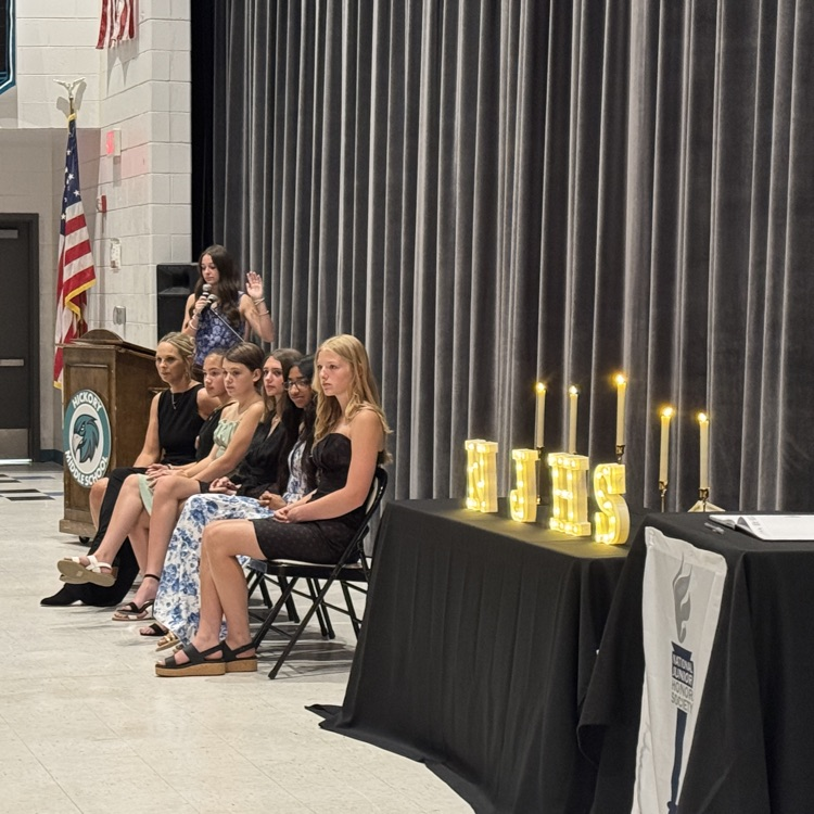student leaders on stage looking on as the new inductees recite the pledge