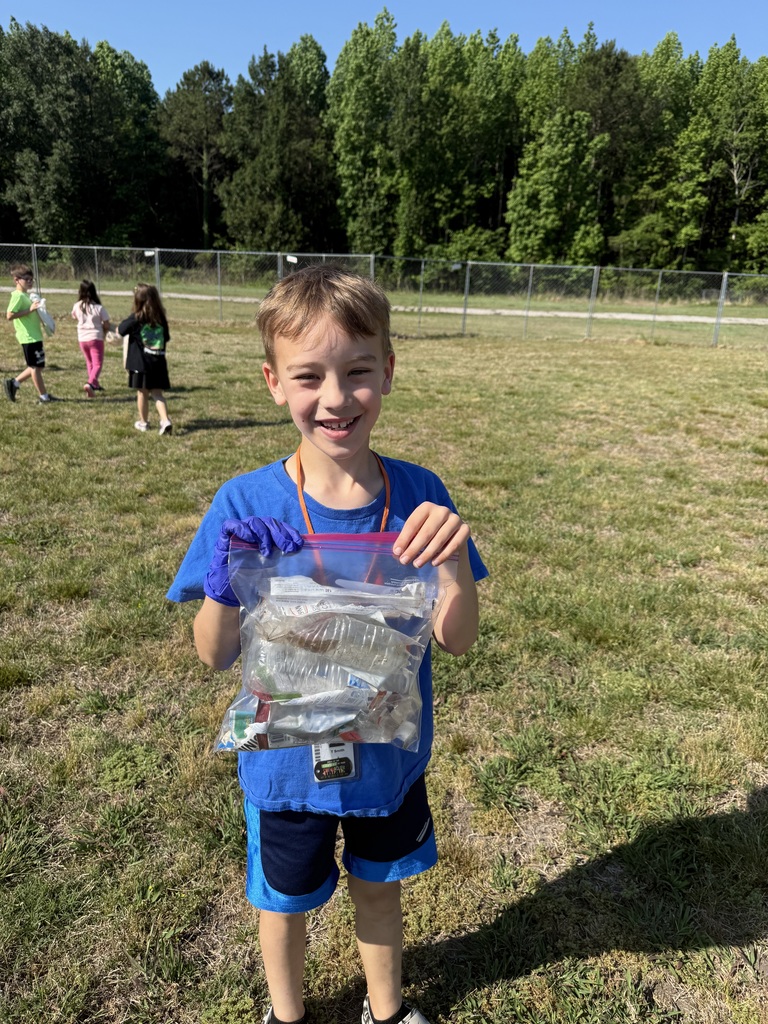 One of Mrs. Charlton's students holding up a zip lock back with trash in it.