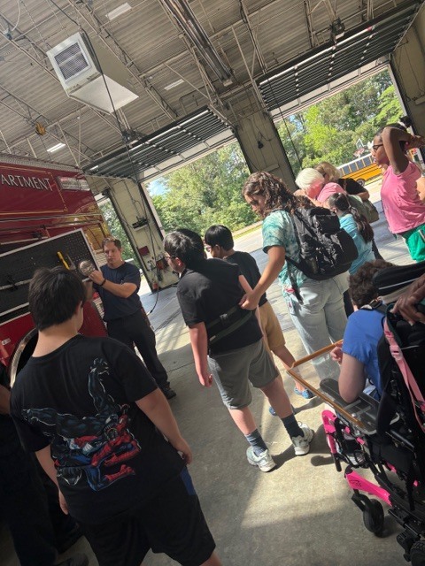 students listening and watching while a firefighter demonstrates 