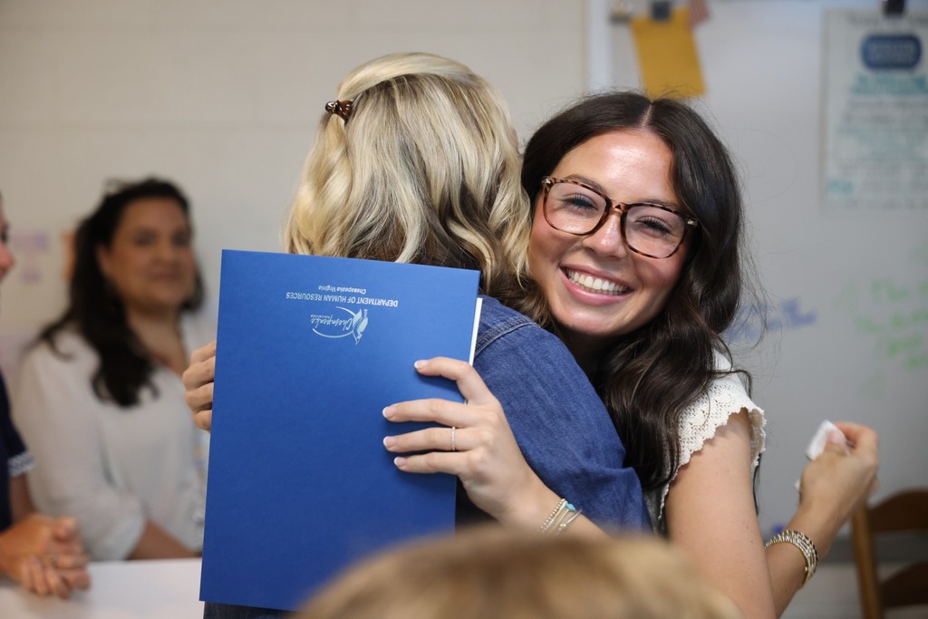 HHS celebrates their Guaranteed contract Recipients with a hug
