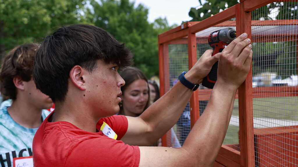 A GFS student uses a drill to fasten a screw