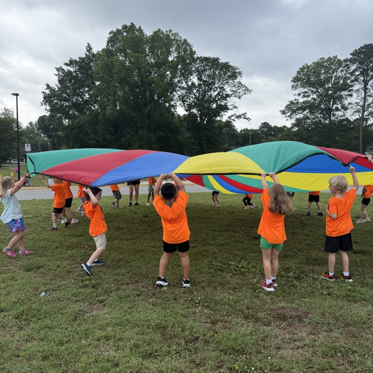 Kindergarten students playing with the parachute at field day