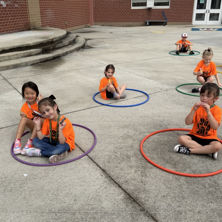 kindergarten students smiling and enjoying their ice pops at field day