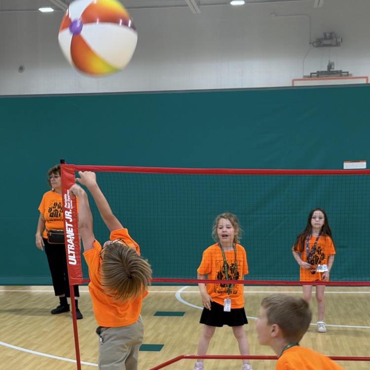 Kindergarten students playing a competitive game of beach ball volleyball at field day