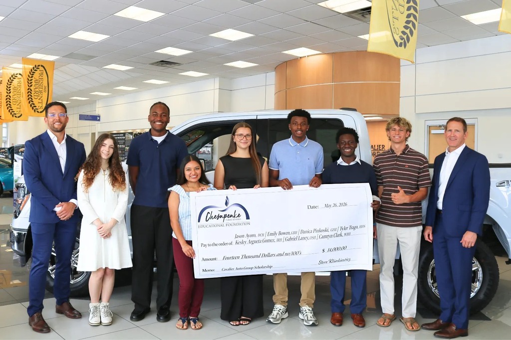 Group of scholarship winners holding a large check. 