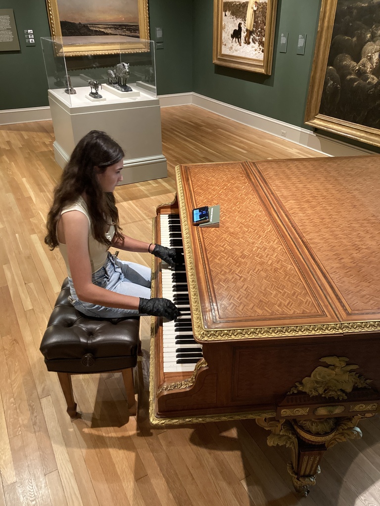 Student playing a piano from the 1800s