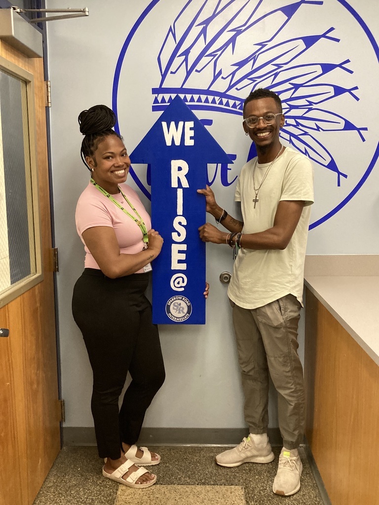 Staff RISE award winners smiling and holding the RISE arrow.