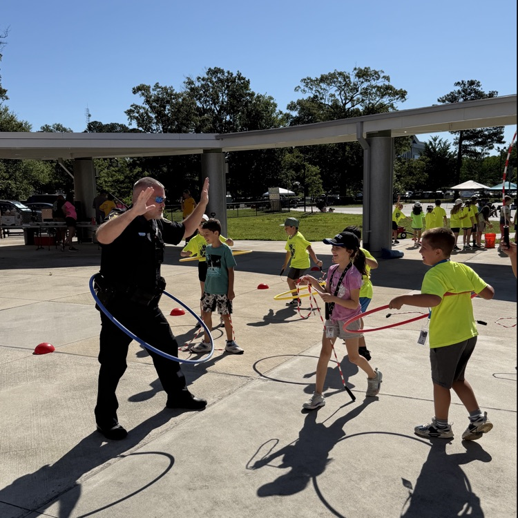 Deputy Spruill hula hooping with Mrs Biglands class on field day
