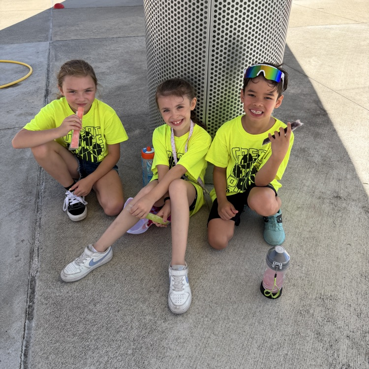students enjoying a much needed break and ice pop on field day