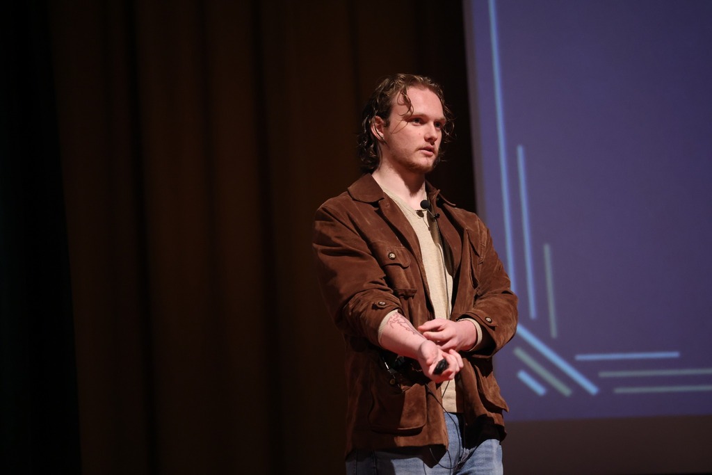 Student touching his tattoo giving his TEDx talk.