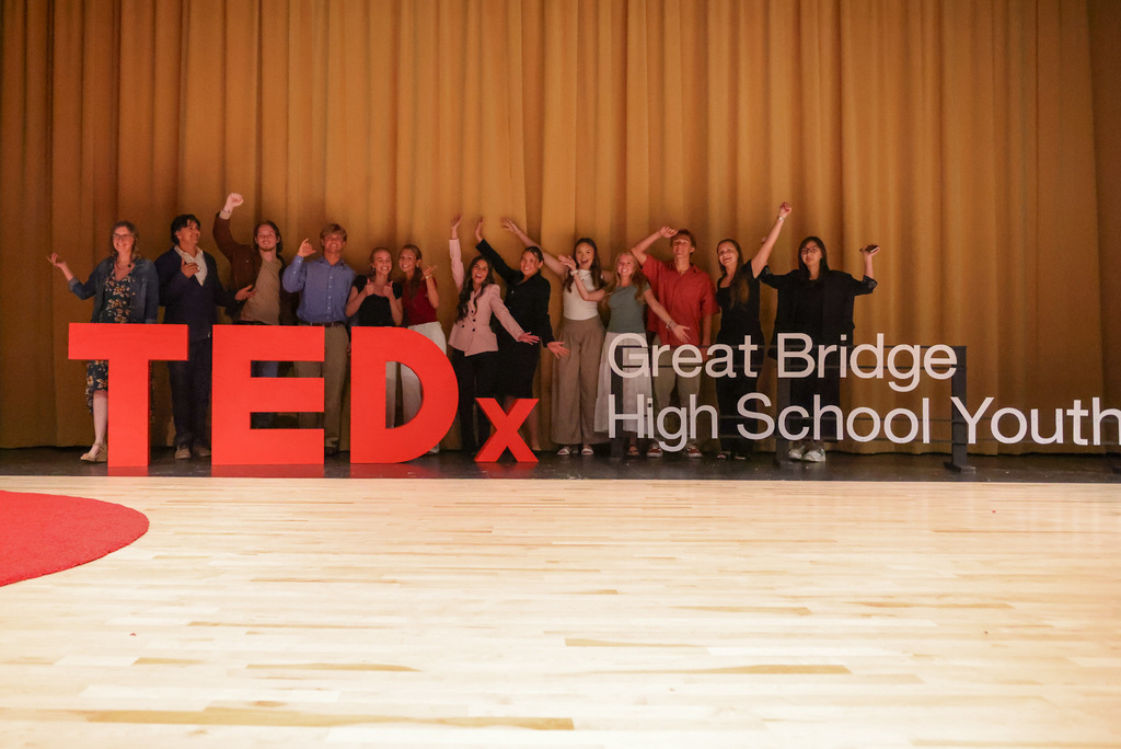 Students behind the TEDx stage setup up happy and smiling at what they just accomplished!
