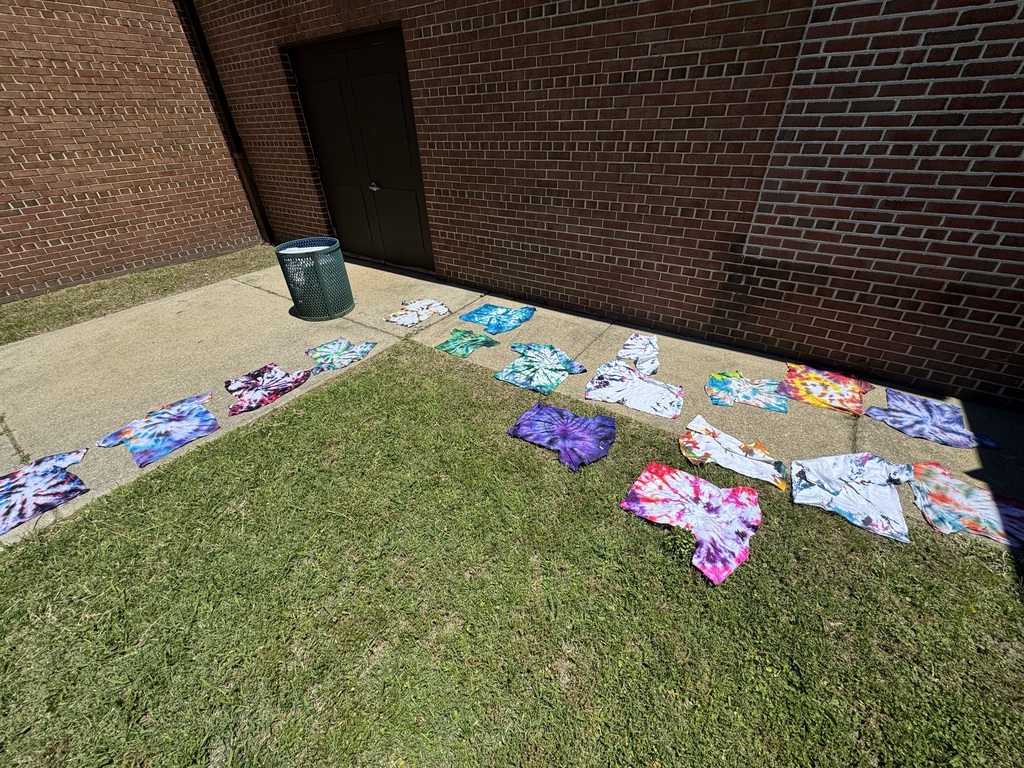 tie-dye shirts drying outside on the sidewalk