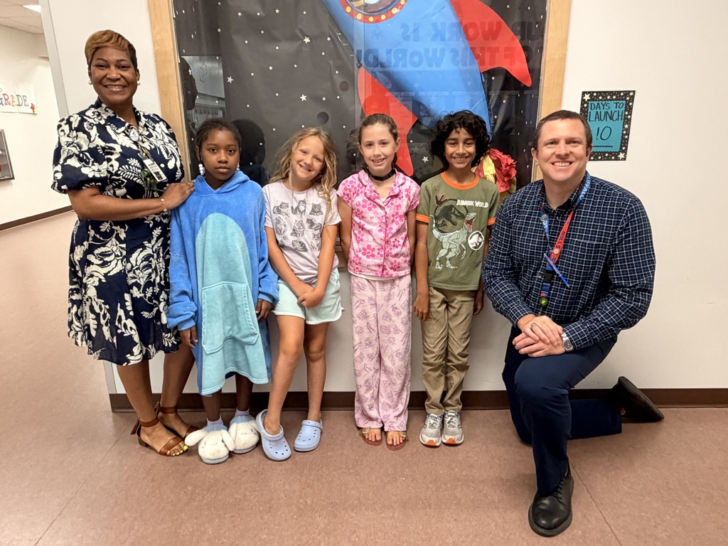 A group of Students of the Month for May posing with the school principal and assistant principal, smiling for the camera in a celebratory recognition photo.