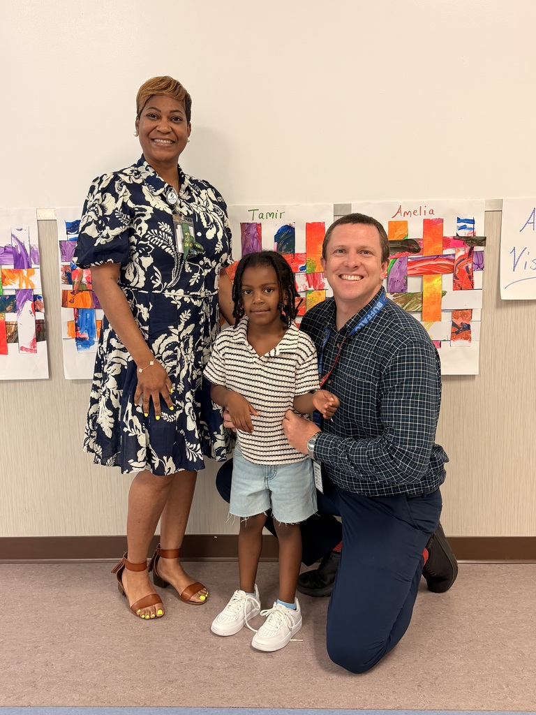 A Student of the Month for May posing with the school principal and assistant principal, smiling for the camera in a celebratory recognition photo.