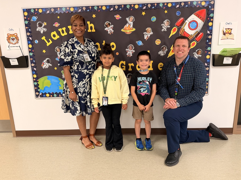 A group of Students of the Month for May posing with the school principal and assistant principal, smiling for the camera in a celebratory recognition photo.