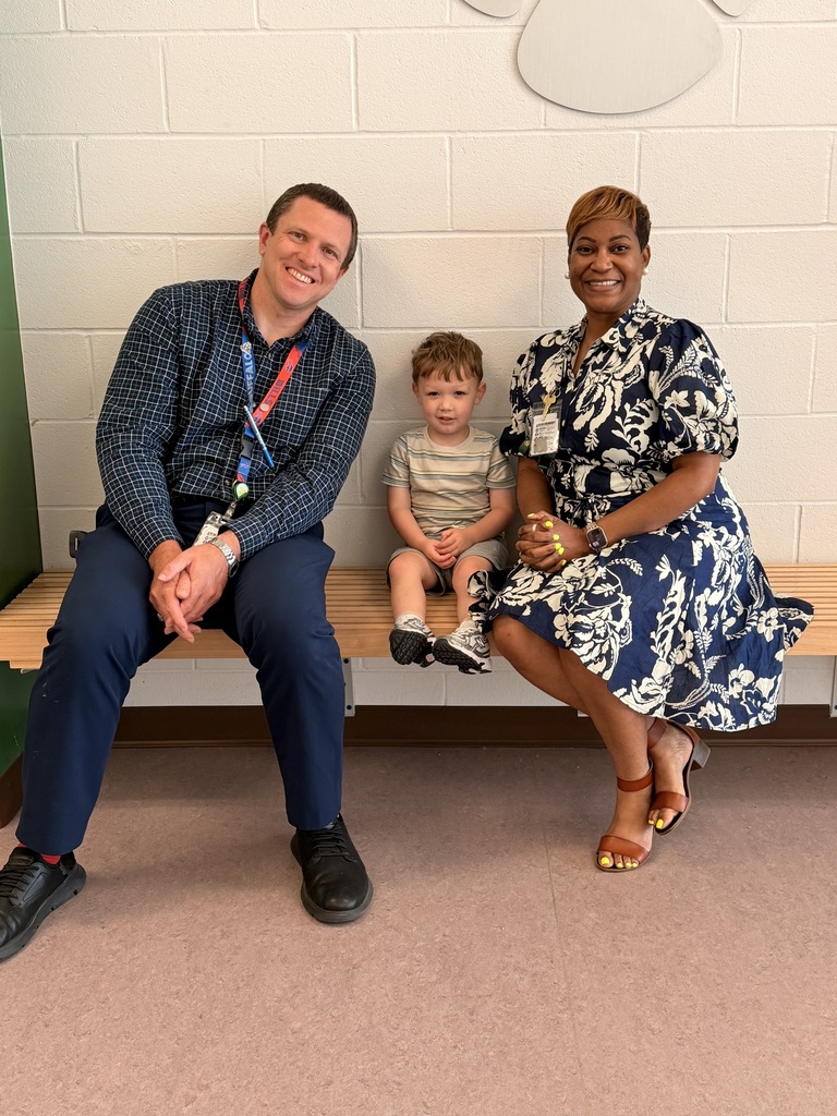 A Student of the Month for May posing with the school principal and assistant principal, smiling for the camera in a celebratory recognition photo.