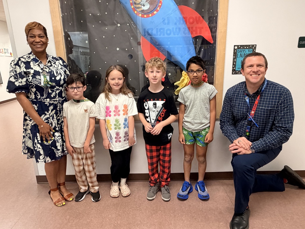 A group of Students of the Month for May posing with the school principal and assistant principal, smiling for the camera in a celebratory recognition photo.