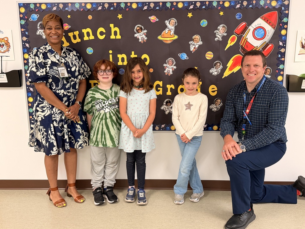 A group of Students of the Month for May posing with the school principal and assistant principal, smiling for the camera in a celebratory recognition photo.