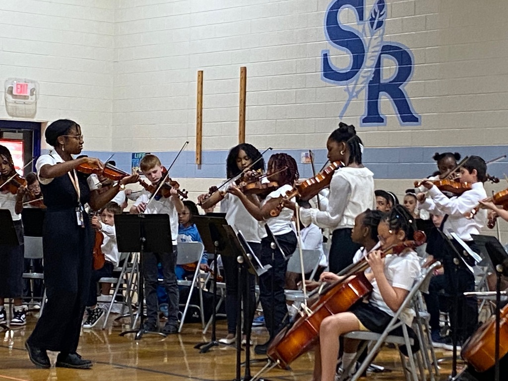 Orchestra students performing in the gym.