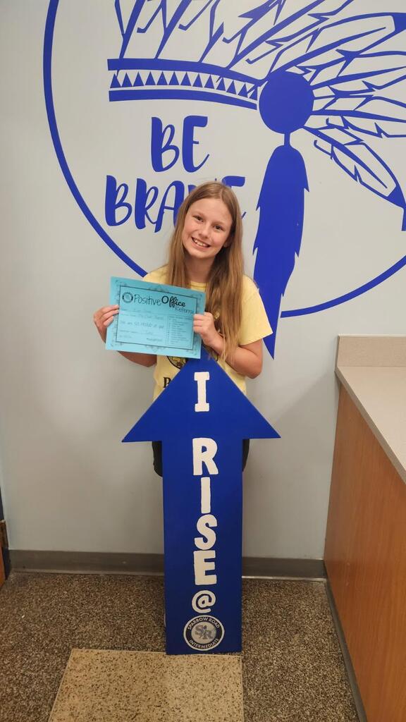 Student proudly holding up Positive Office Referral with the I RISE arrow.