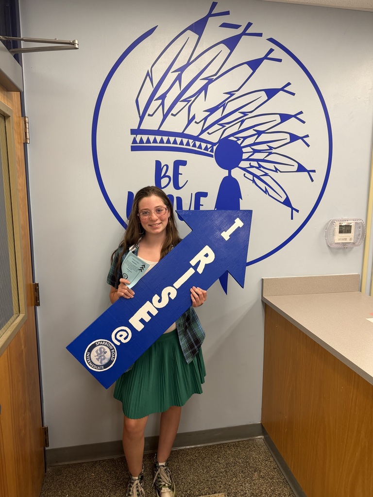 Student proudly holding up the I RISE arrow.
