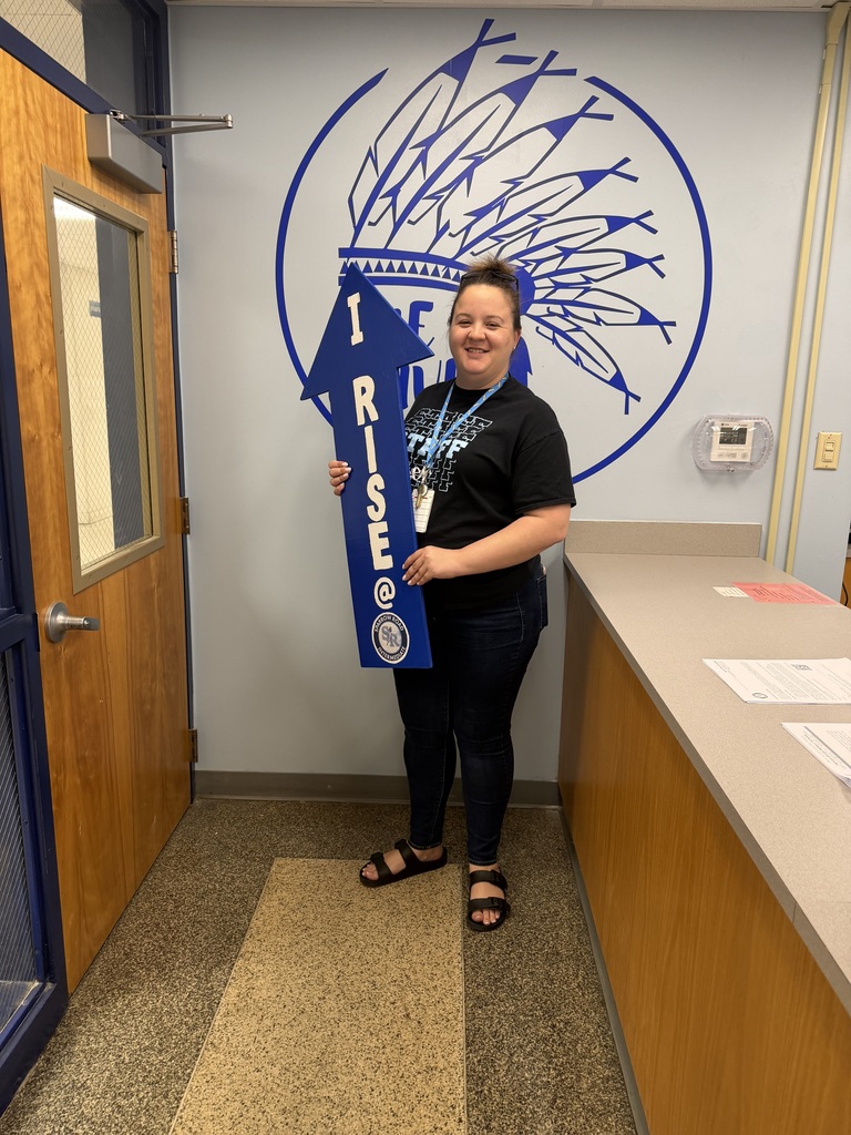 Mrs. Jarvis excitedly holding up the I RISE arrow.