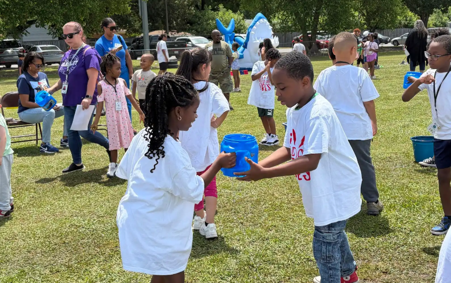 students playing at the water station