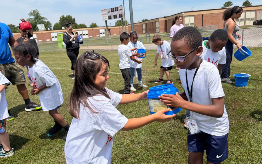 students playing at the water station
