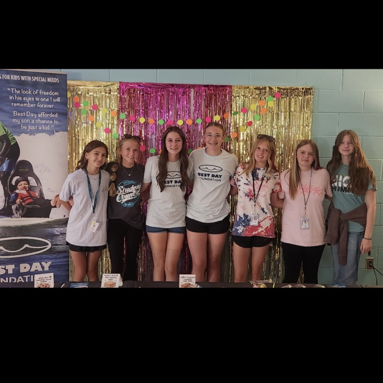 SCA members smiling in front of backdrop