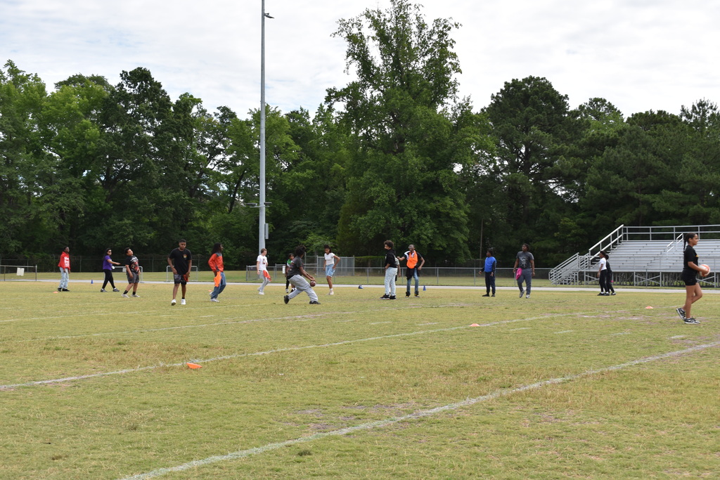 Kids playing sports at field day.