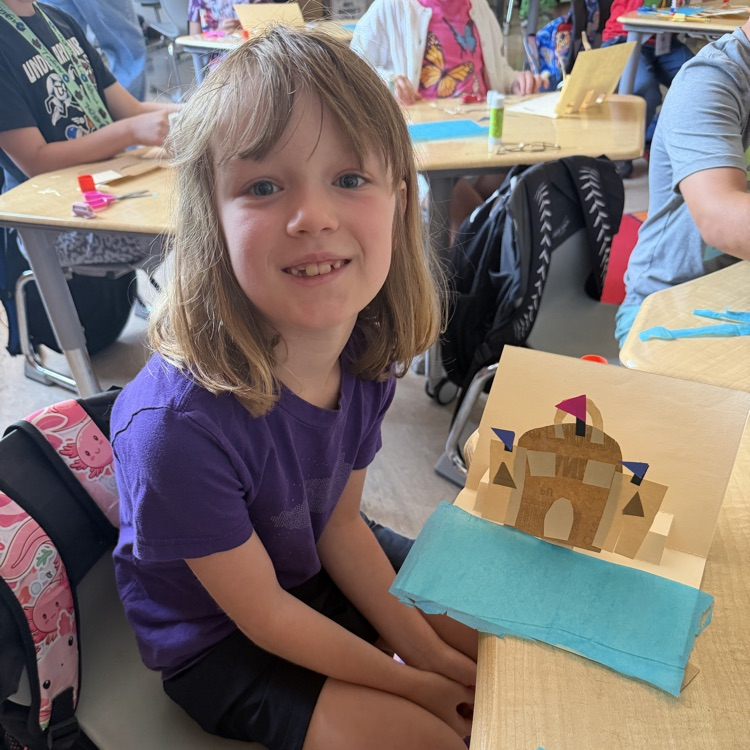 student showing off her 3D sand castle 