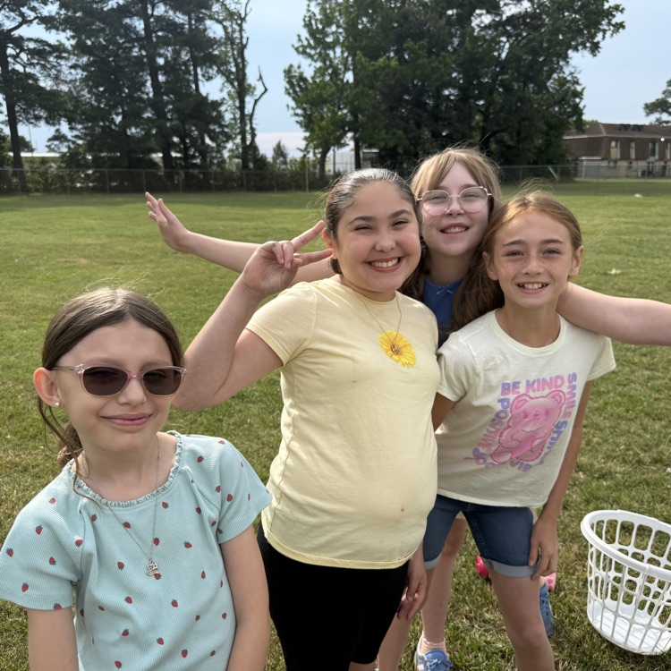 Group of groups smiling outside at field day. 
