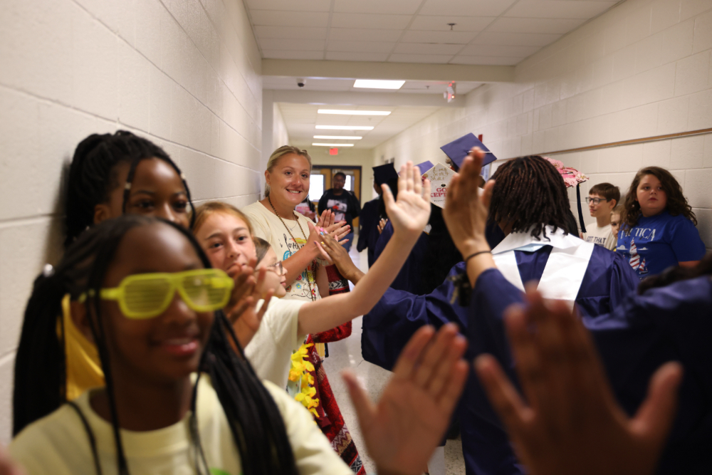 SRI students giving out high fives to IRH students in the hallway.