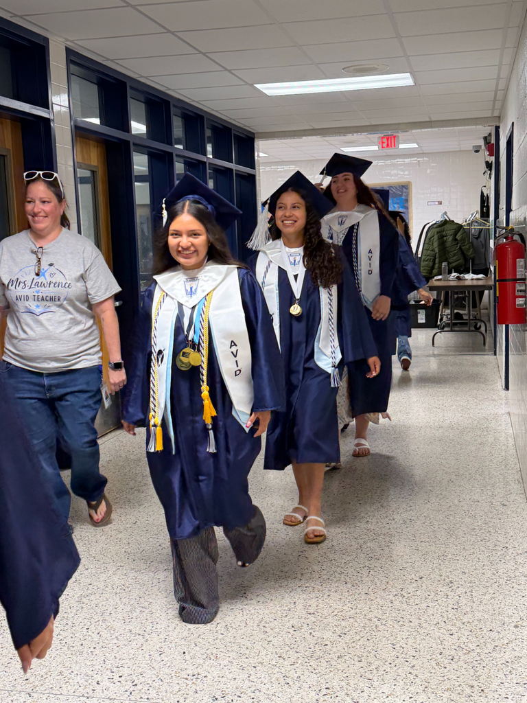 IRH students starting their walk down the halls of SRI in their caps and gowns.