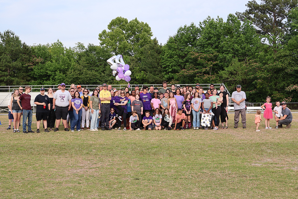 Group of people with retiring teacher on football field