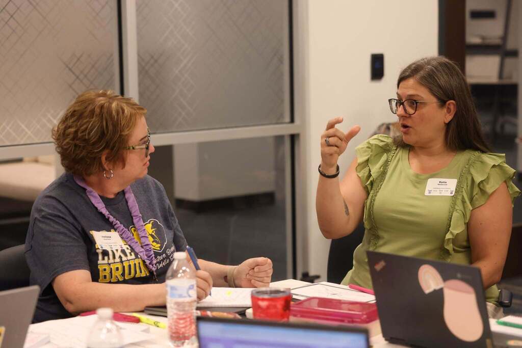Two educators talking with each other at a breakout session.