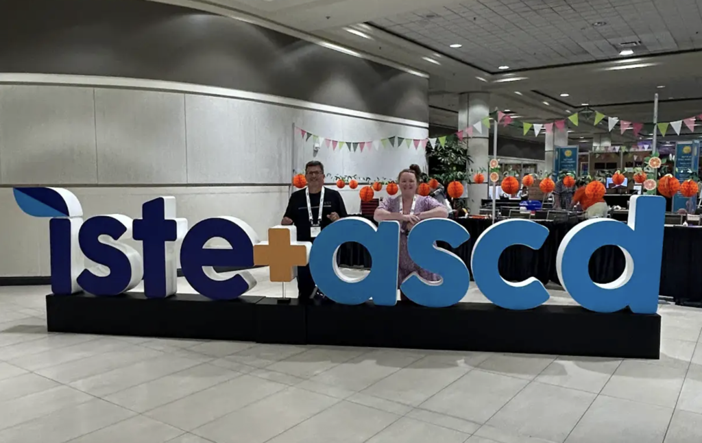 Teachers standing in front of the ISTE + ASCD conference welcome sign.