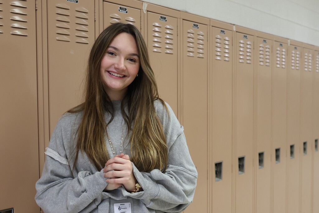 student smiling for camera at her locker