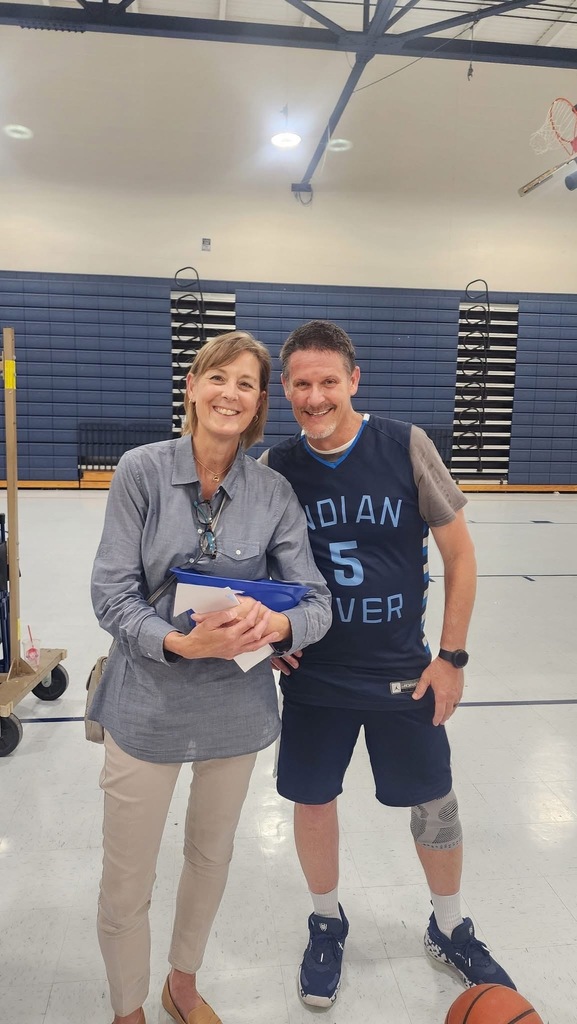 A smiling picture of Mrs. Boerboom, the new Assistant Principal , and Mr. Triolet, standing in front of the bleachers in the gym..