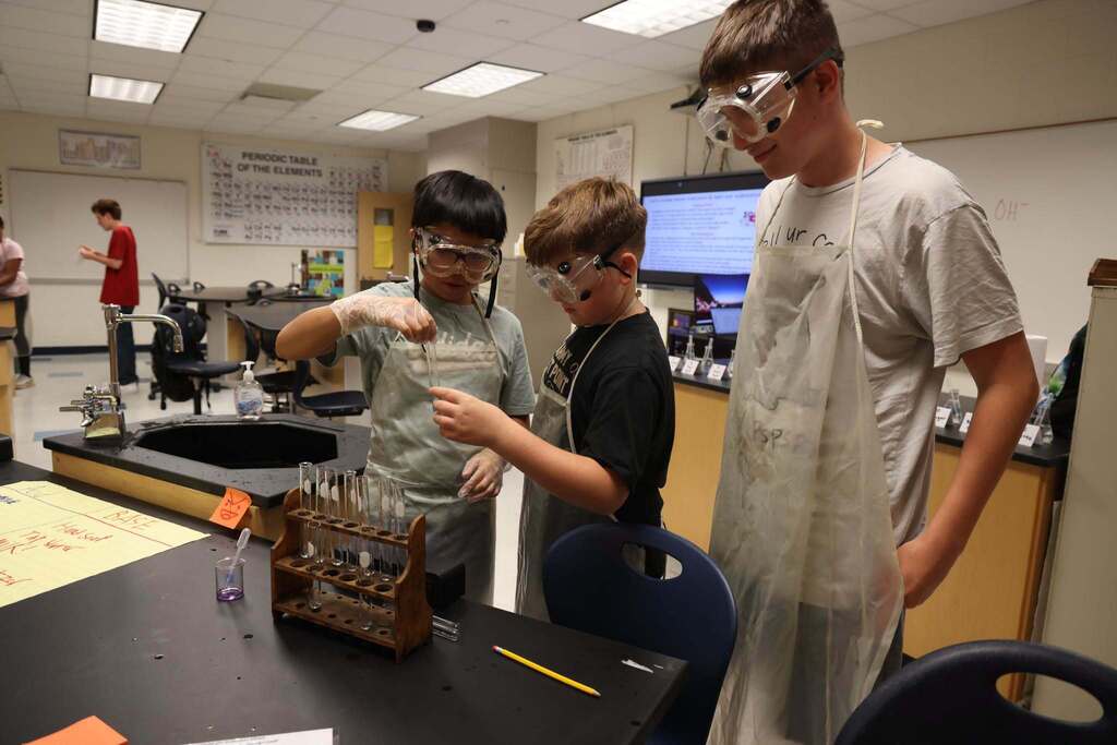 3 students experiment with acids and bases