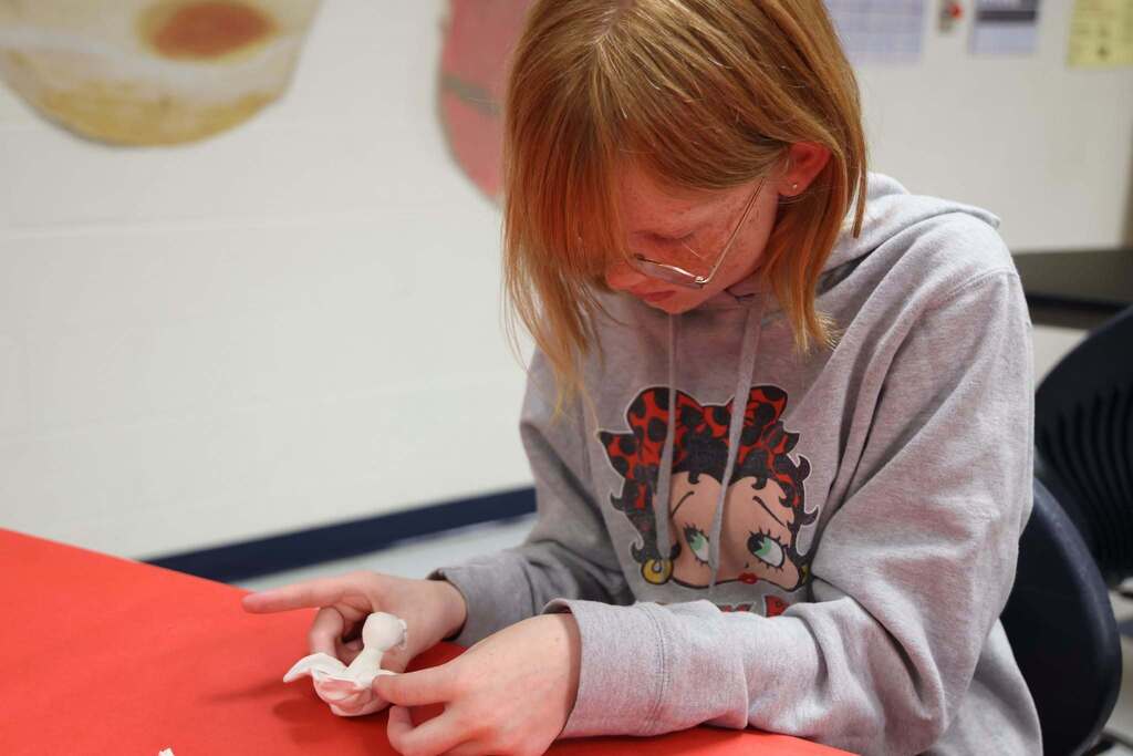 student creates a clay bird