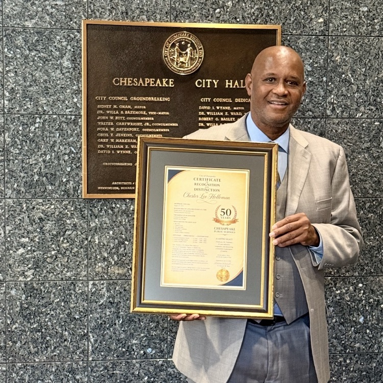 Coach Holloman standing proudly with his plaque