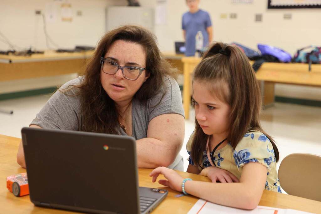 Student and teacher learn on chromebook
