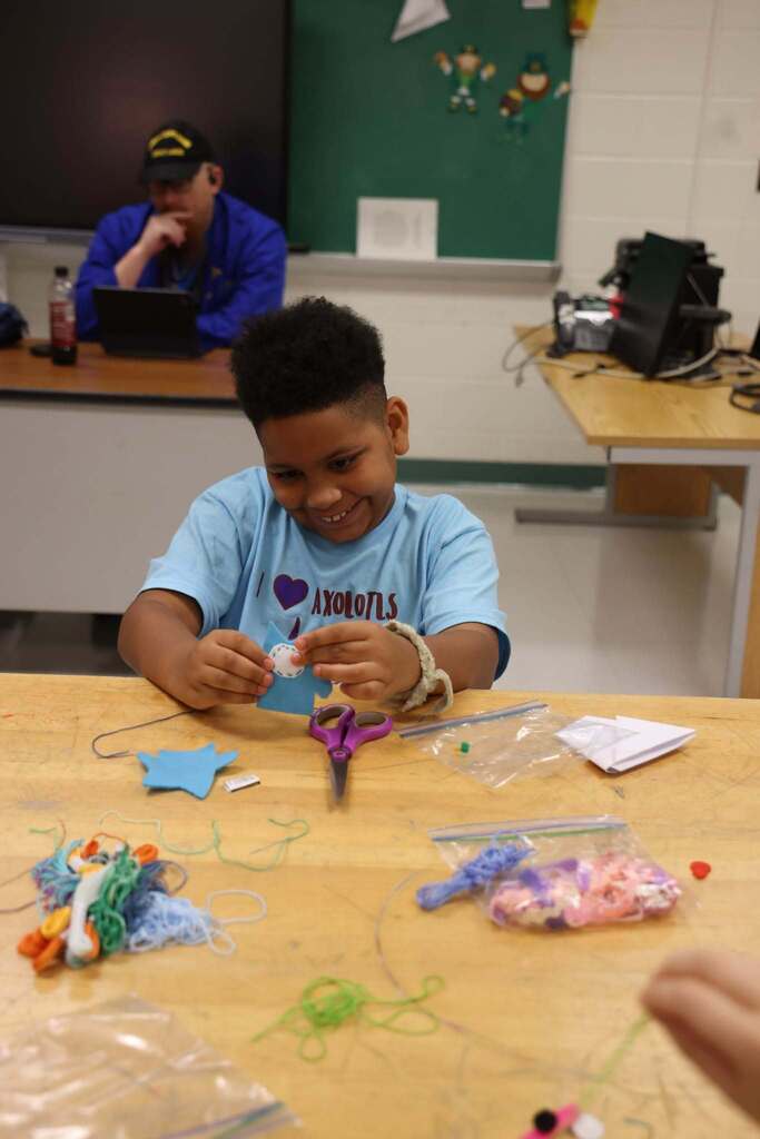 student happily creates felt animal at CTE camp